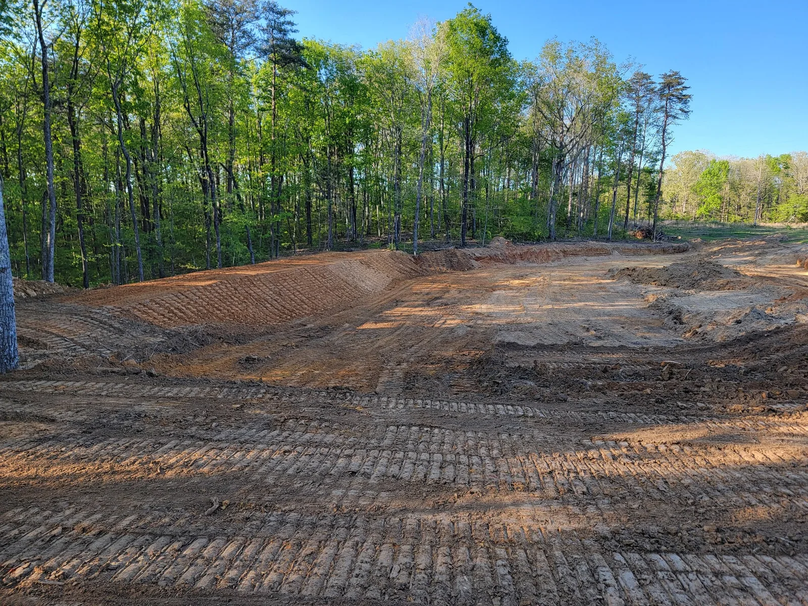 Pond dam built and compacted in red clay before the slopes are dressed