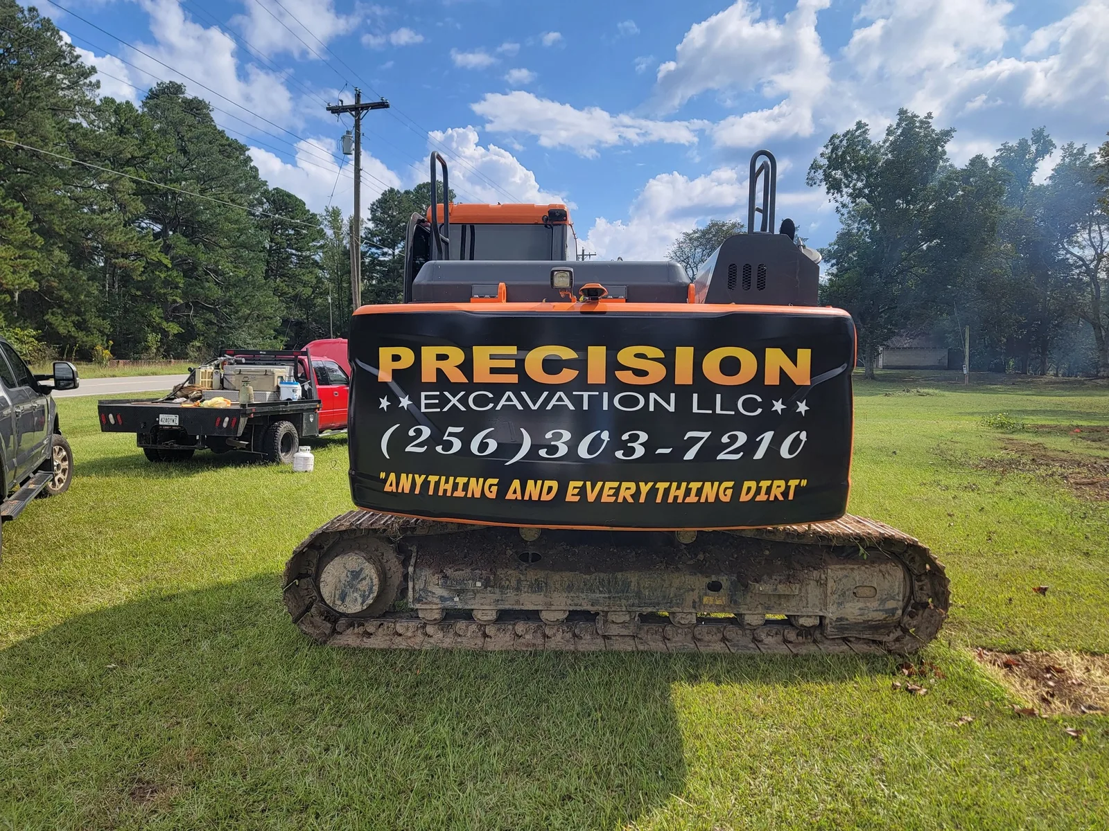 Precision Excavation LLC lettering and phone number on the back of one of our trackhoes