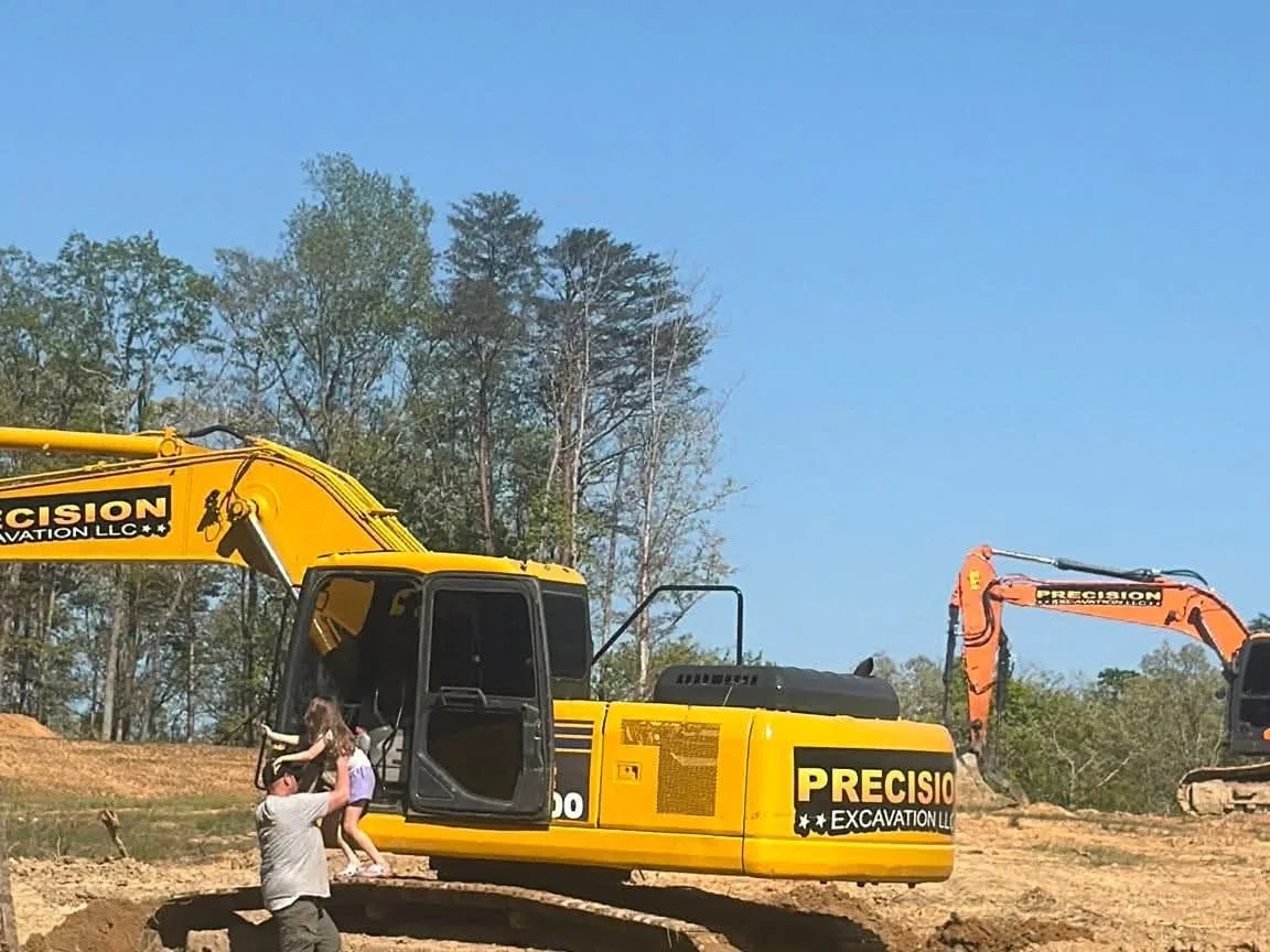 Trackhoe shaping the dam on a pond build