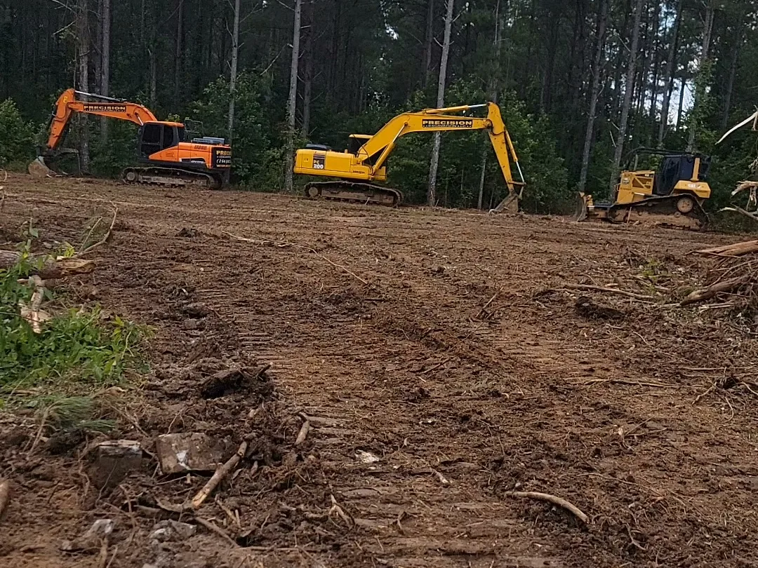 Two trackhoes on a cleared pad